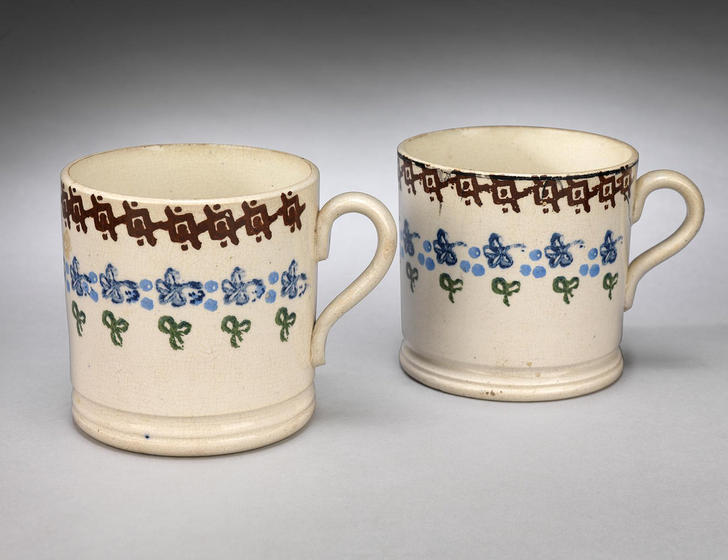 A Pair of Loop Handled Spongeware Mugs with Moulded Foot