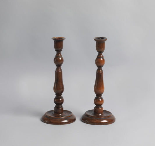 A Pair of Early Yew Wood Table Candlesticks